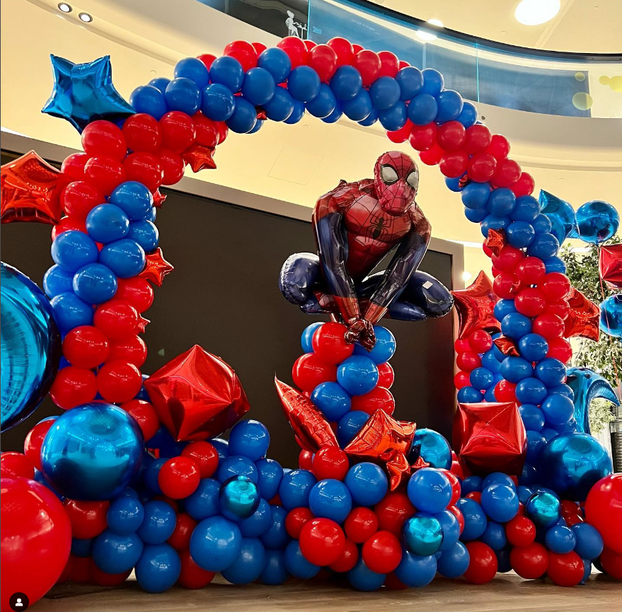 Balloon display with red and blue balloons, including Star-shaped balloons, and a Spider-Man figure balloon in the center.