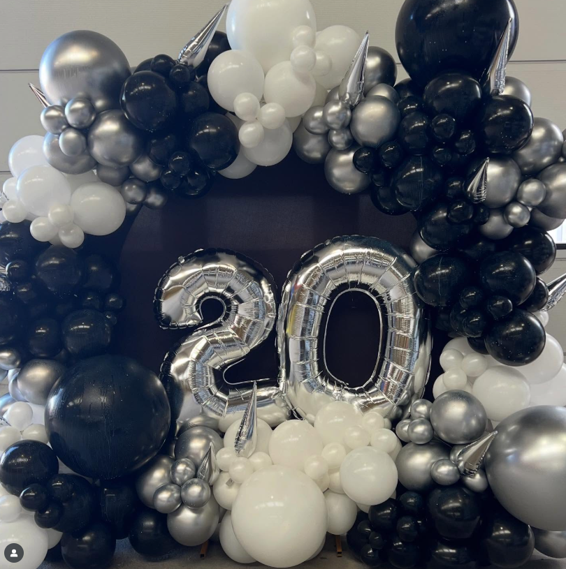 Black, white, and silver balloons shaped into a 20th birthday celebration with large balloon numbers '20' in the center.