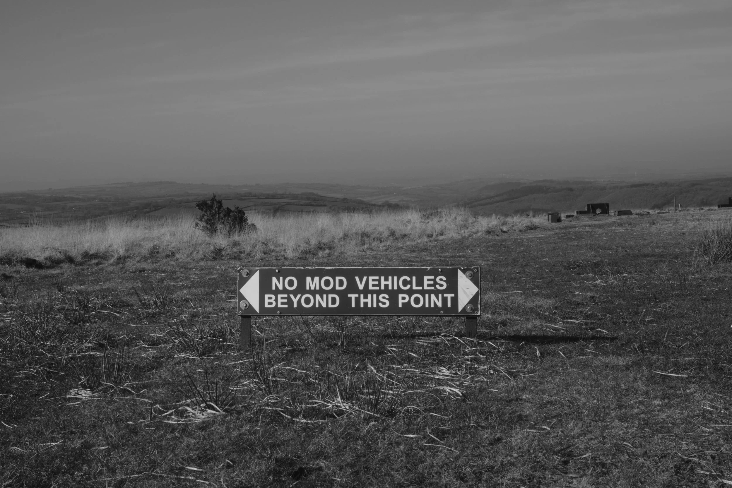 A sign in a field that says, 'No MOD vehicles beyond this point,' with an arrow pointing left.