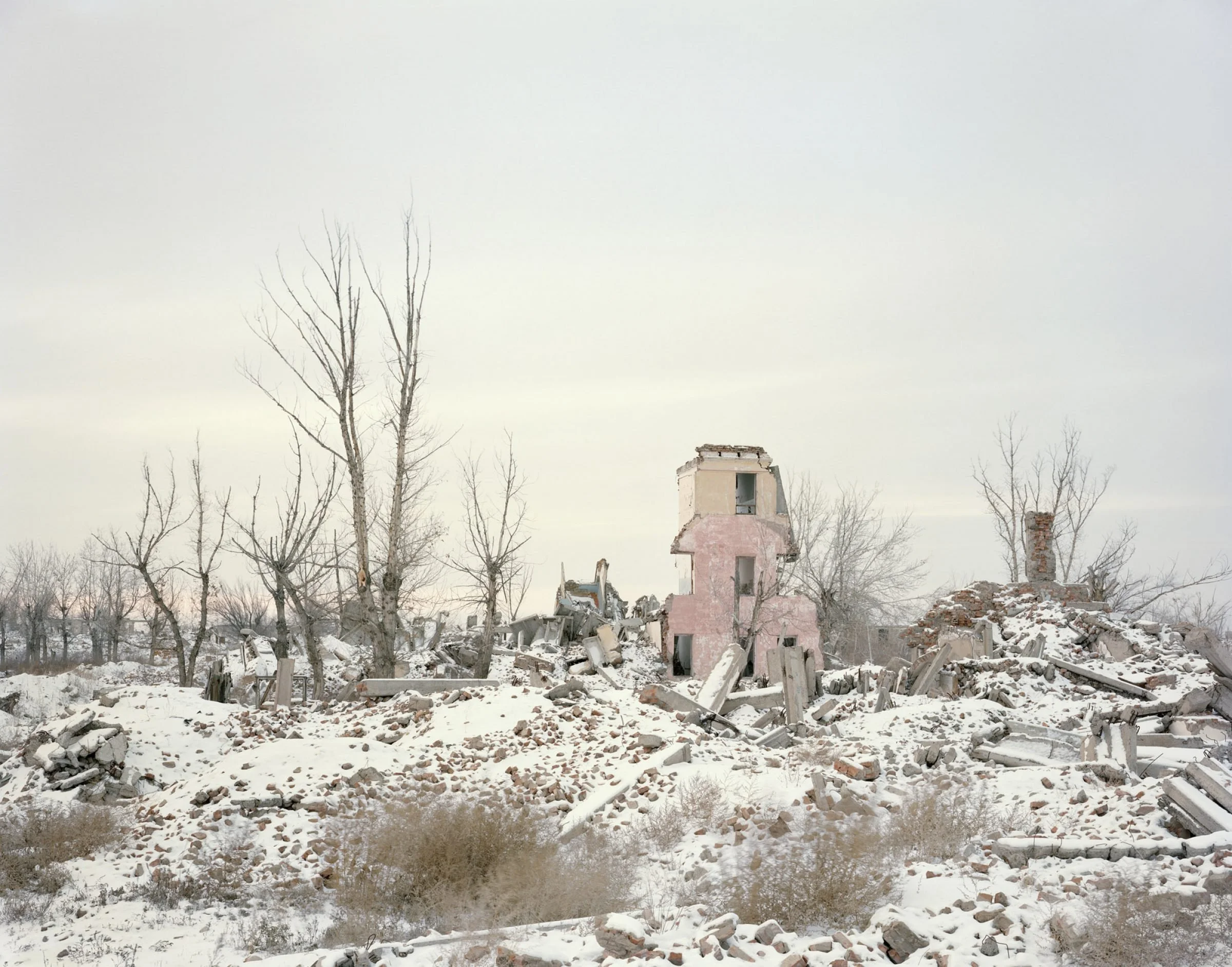 Photograph of Kurchatov research facility in ruin with bare trees and snow surrounding it from Nadav Kander's Dust project