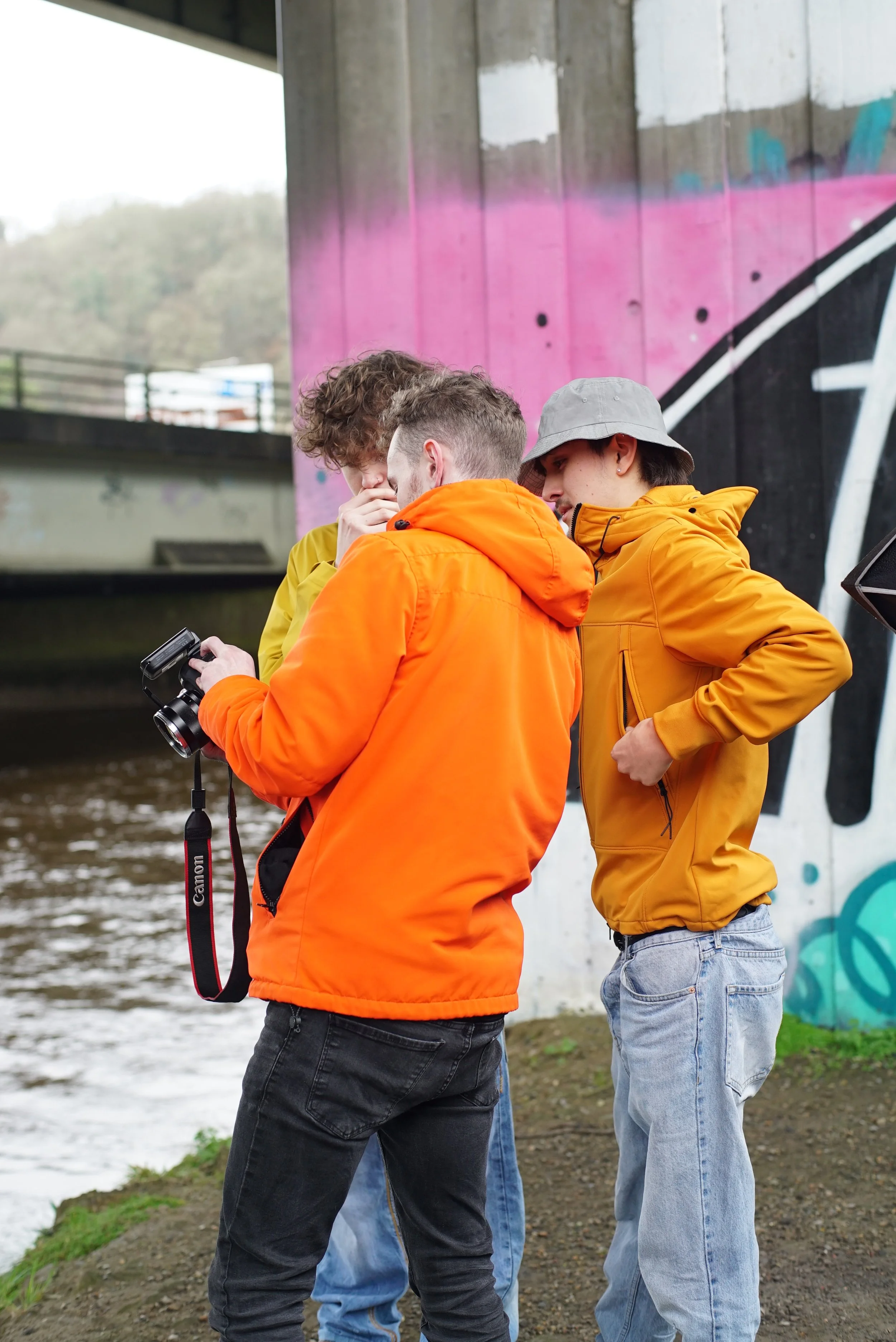 A photographer shows two models wearing CP Company jackets the screen of a Canon 6D II.