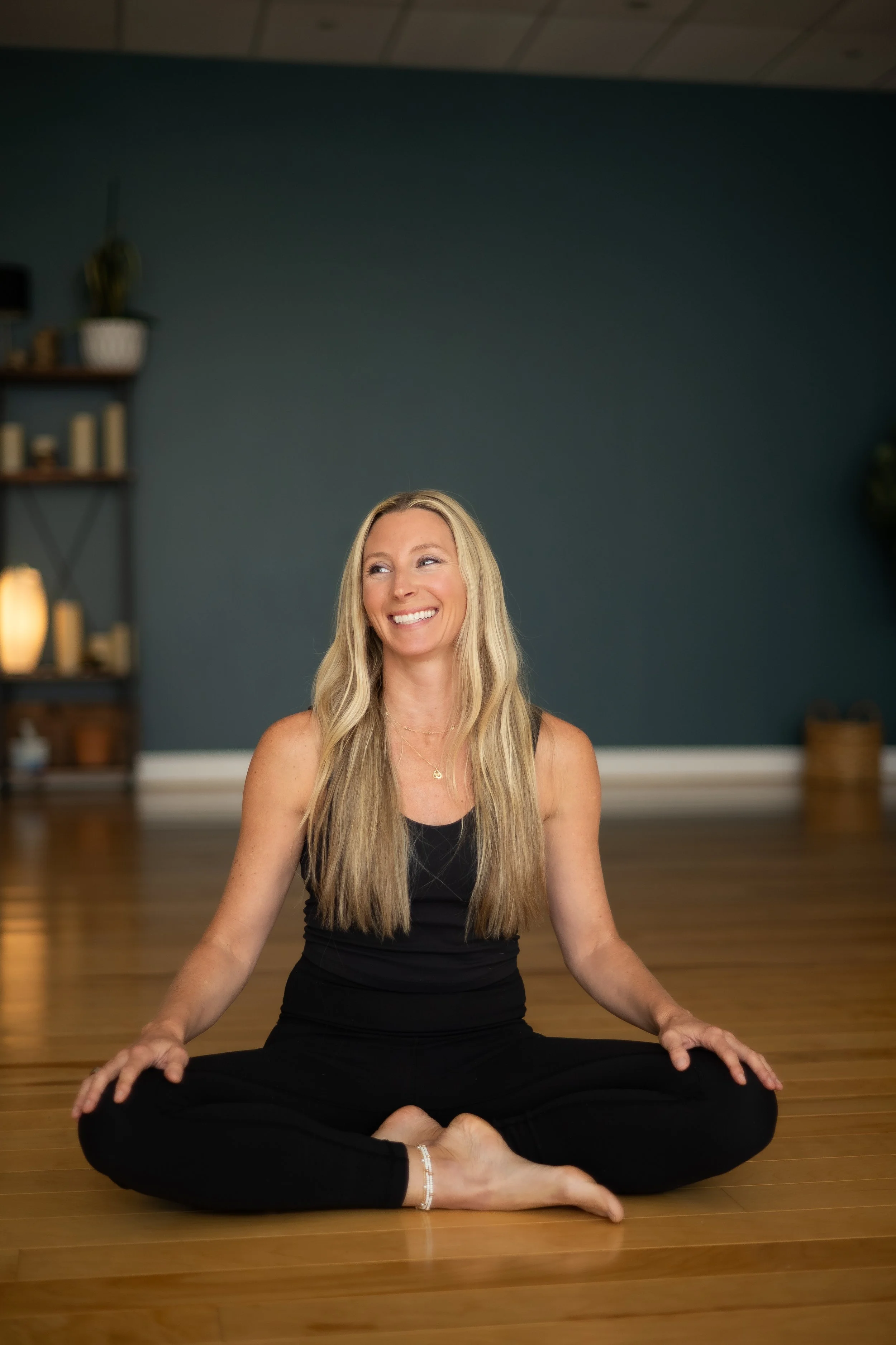 A Franklin, TN yoga teacher sitting on the floor in a relaxing seated position - representing mindfulness, stillness and self-connection.