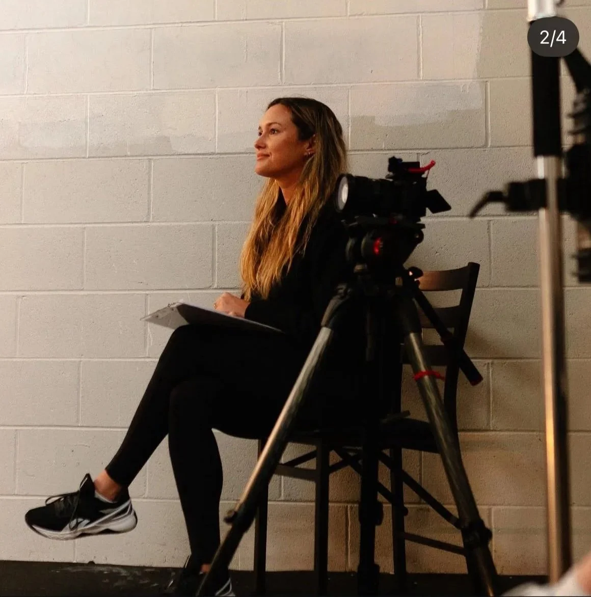 Woman interviewing a subject while she's sitting next to the camera 