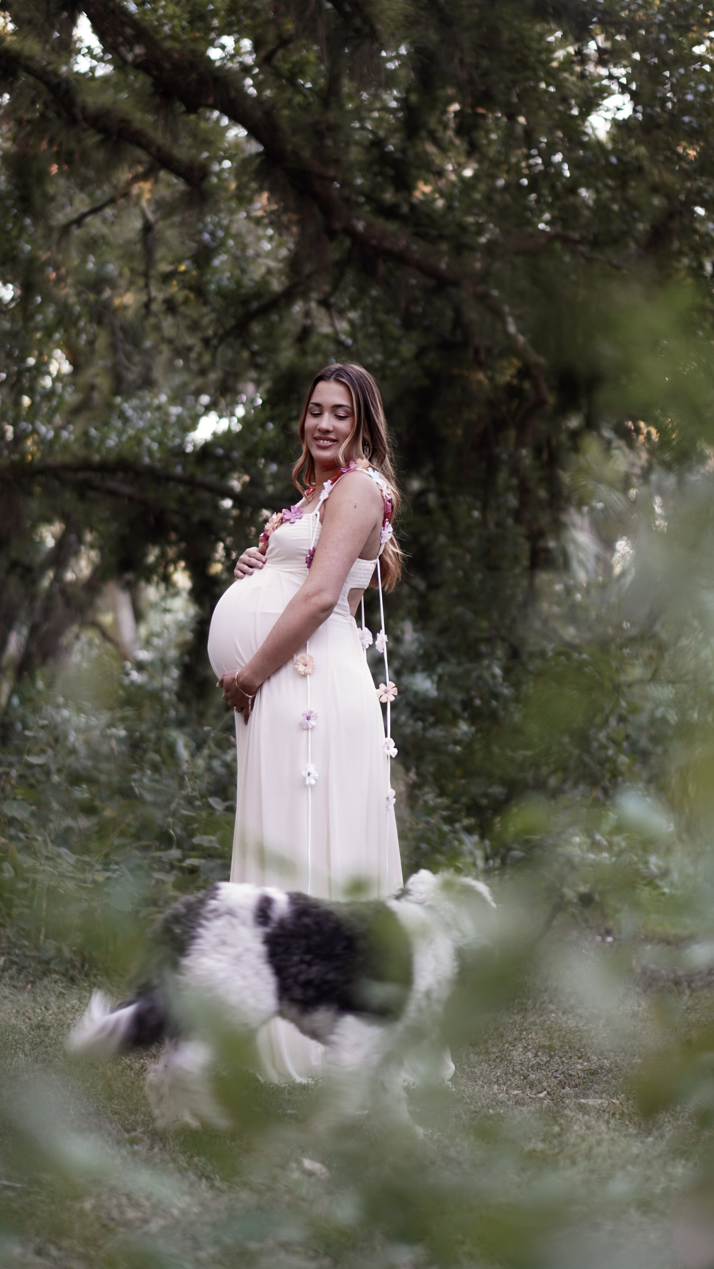Close-up of a woman and man holding hands, the woman wearing a white dress and gold bracelet.
