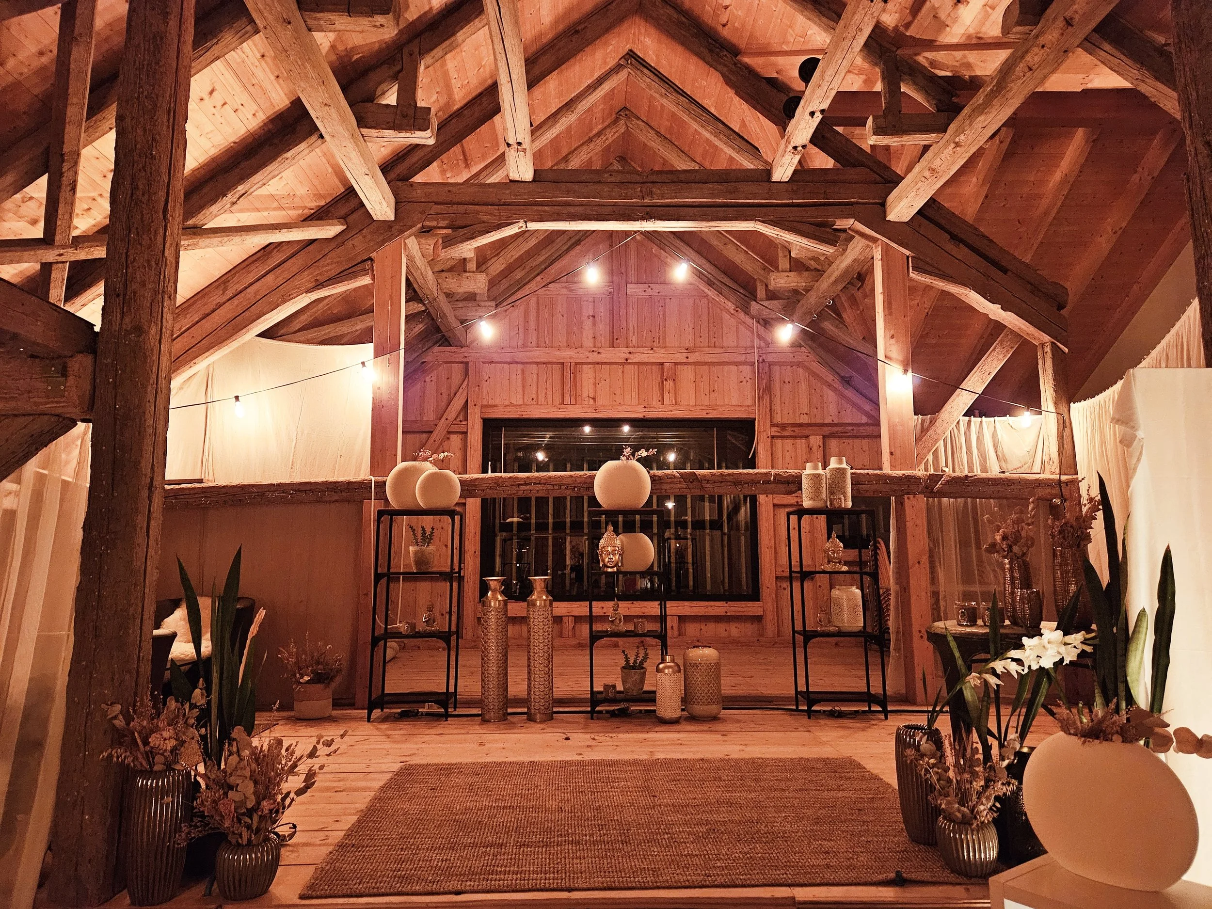 Ein gemütlicher, gut beleuchteter Raum mit einer Holzkonstruktion und Dekorationen wie Vasen, Lampen und Pflanzen, im skandinavischen Stil. Ein Ort der Ruhe und Kraft für Persönlichkeit Arbeit ausstrahlt.