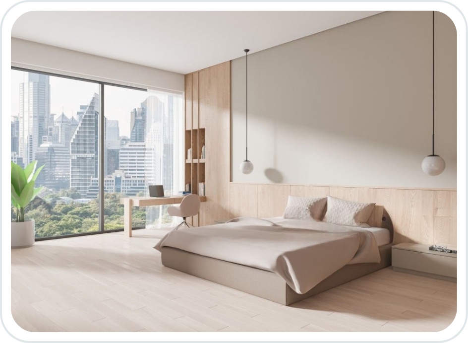 Modern bedroom with a large window overlooking a city skyline, a bed with neutral bedding, a nightstand, and a small workspace with a desk and chair, decorated in light wood tones and minimal decor.