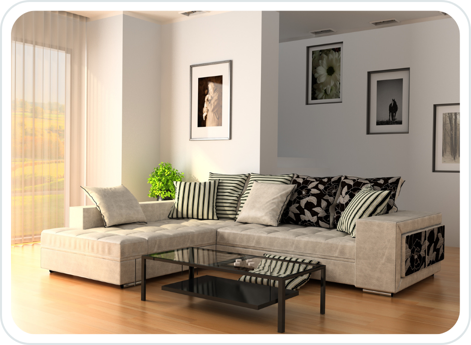 Modern living room with beige sectional sofa, black and white pillows, glass coffee table, potted plant, and framed artwork on white walls.