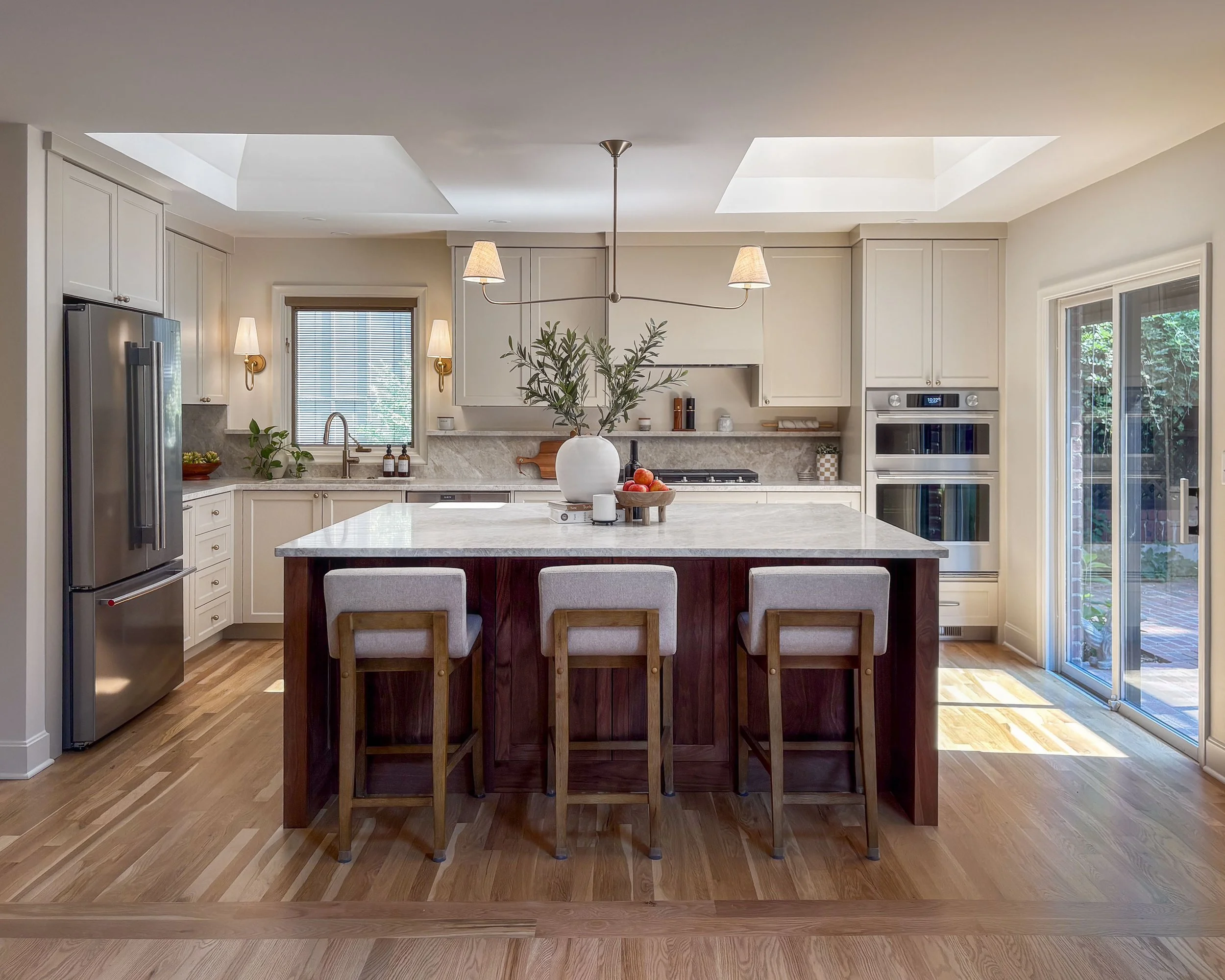 Remodeled Prairie Village kitchen with painted cabinetry, a walnut island, Taj Mahal countertops, and two large skylights.