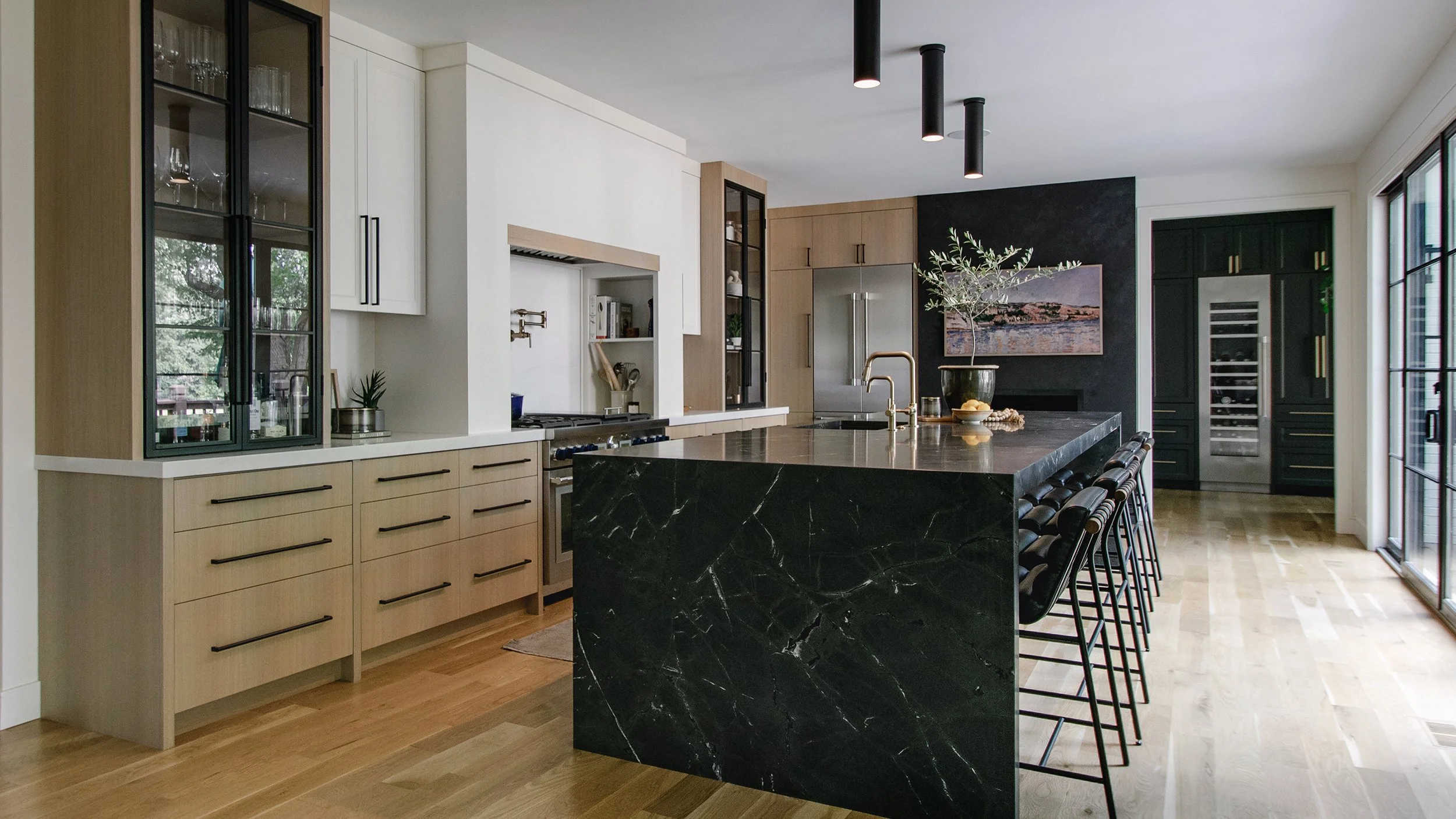 Award-winning kitchen remodel on Ward Parkway in Kansas City featuring custom white oak cabinetry, a waterfall stone island, integrated appliances, and refined modern detailing by Erica Kay Design & Remodeling.