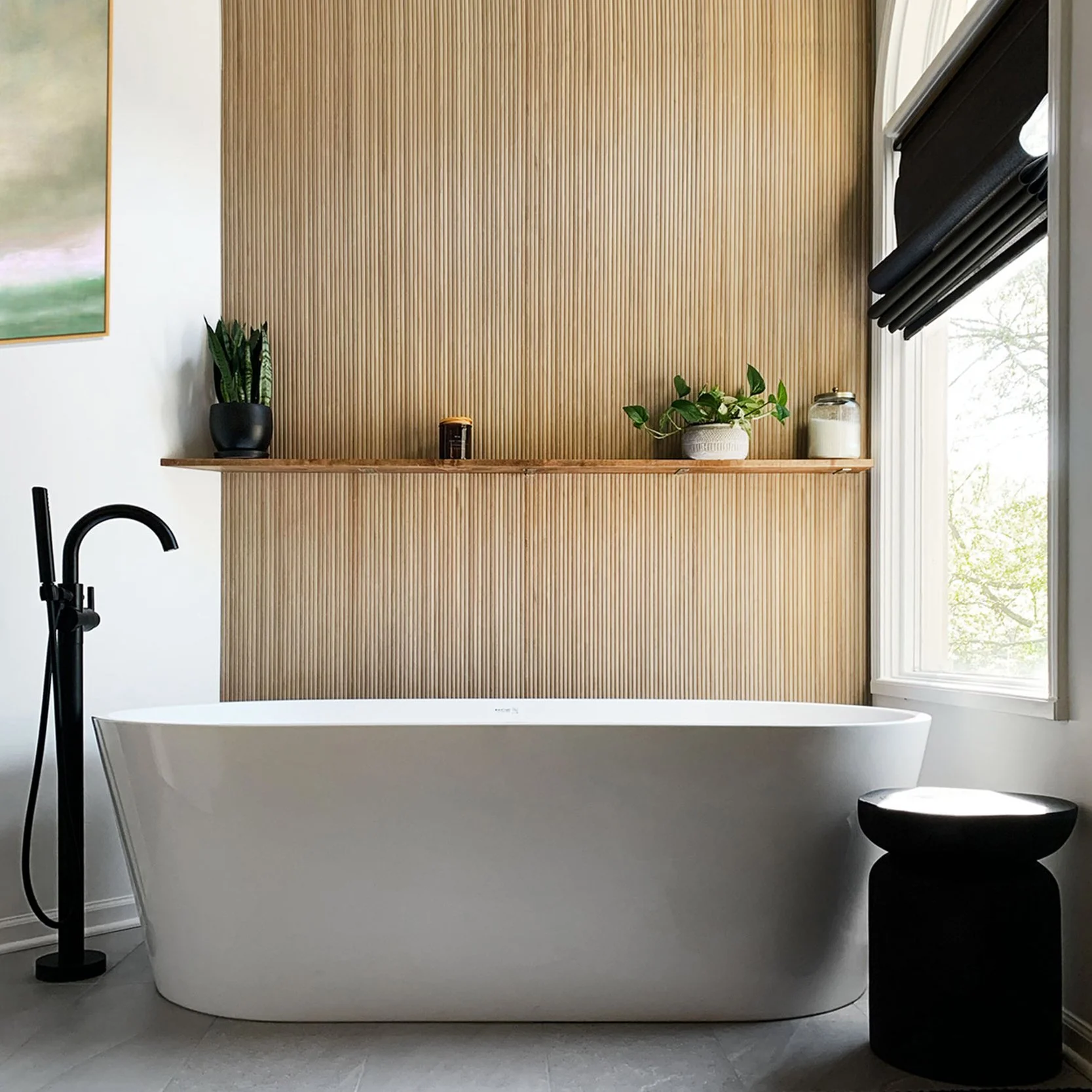 Spa-inspired primary bathroom remodel in Prairie Village with vertical tile, freestanding tub, and black plumbing fixtures by Erica Kay Design.