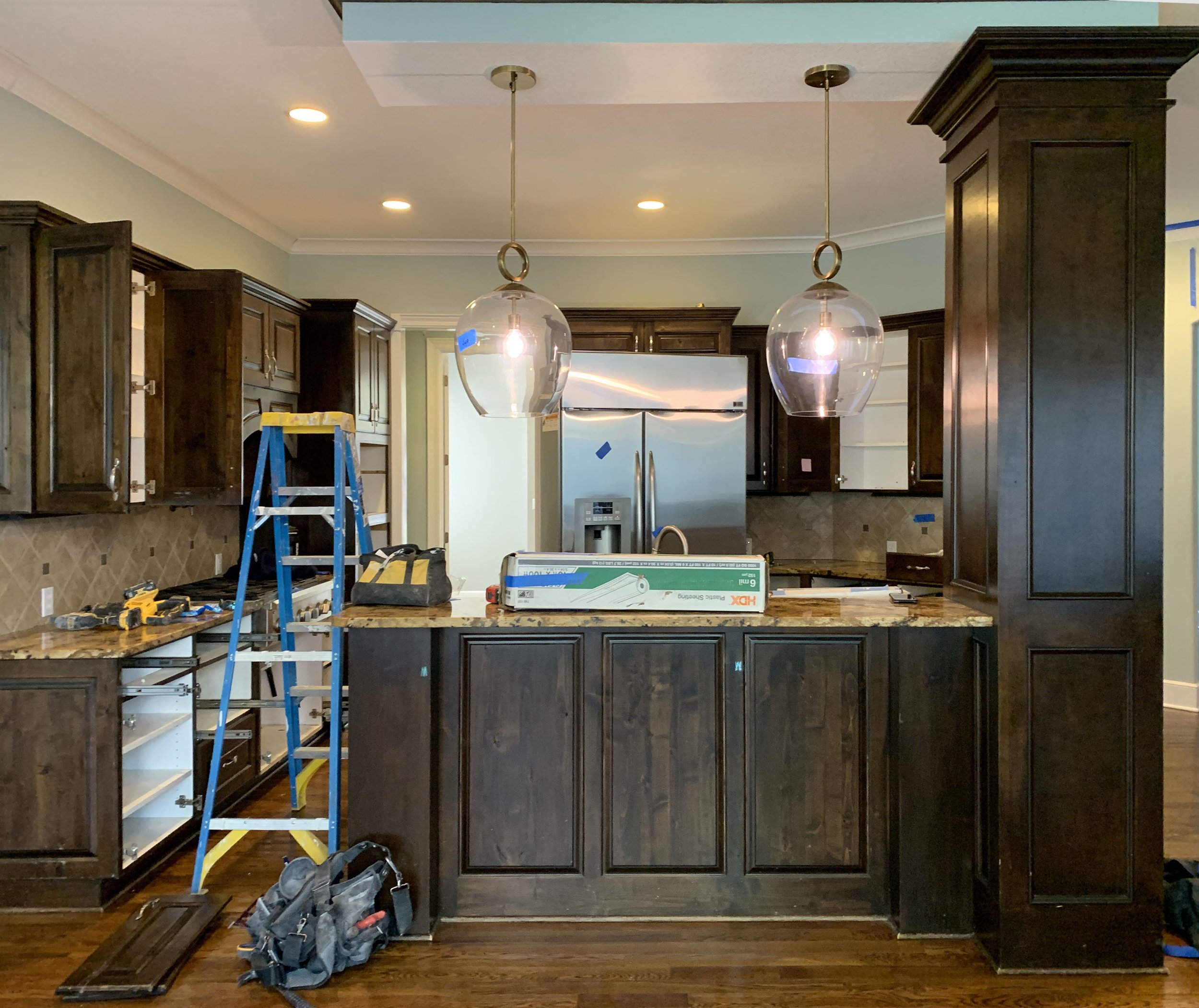 Outdated dark cabinetry, countertops and backsplash.