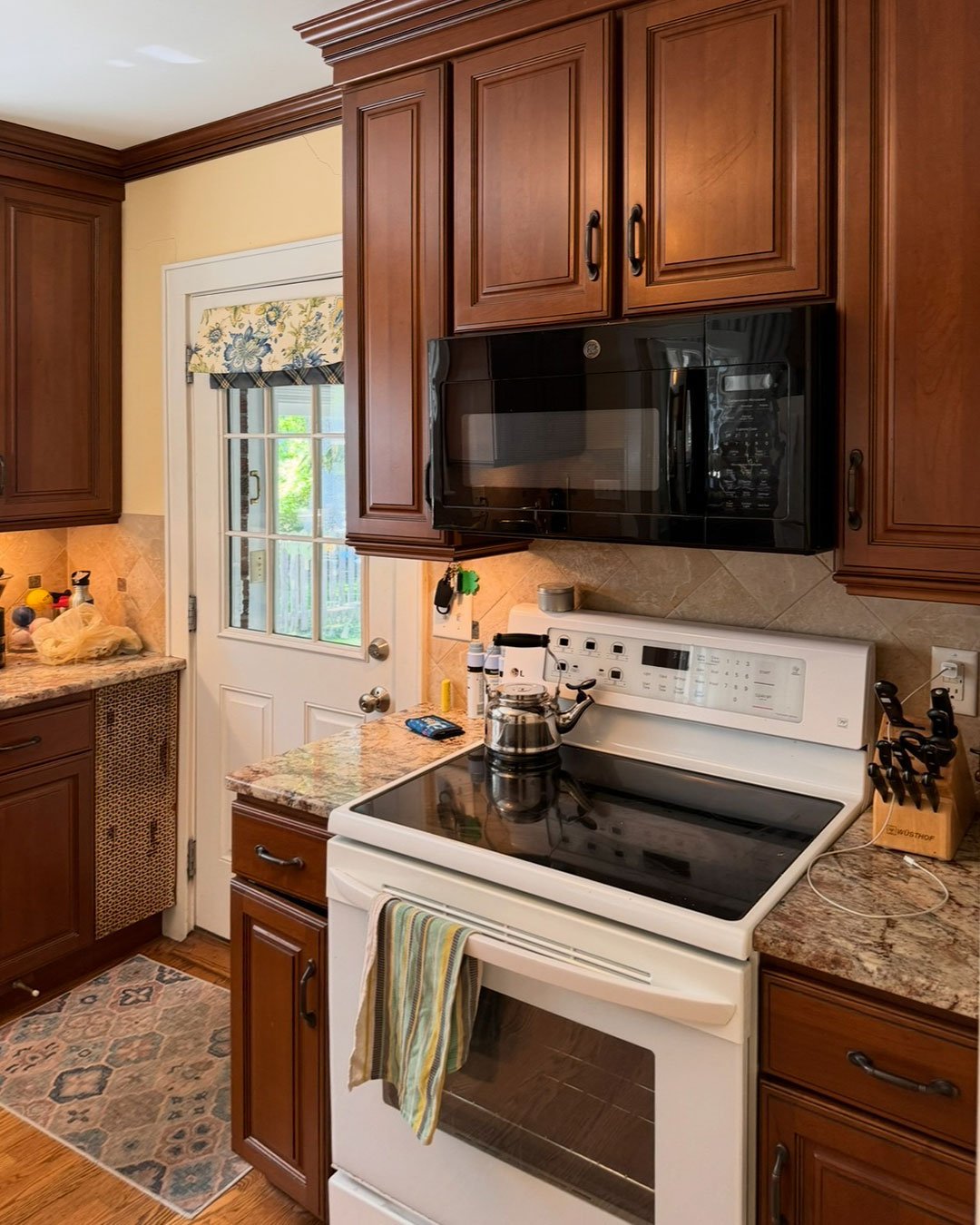 Brookside kitchen before renovation, with dark wood cabinetry and a white refrigerator.