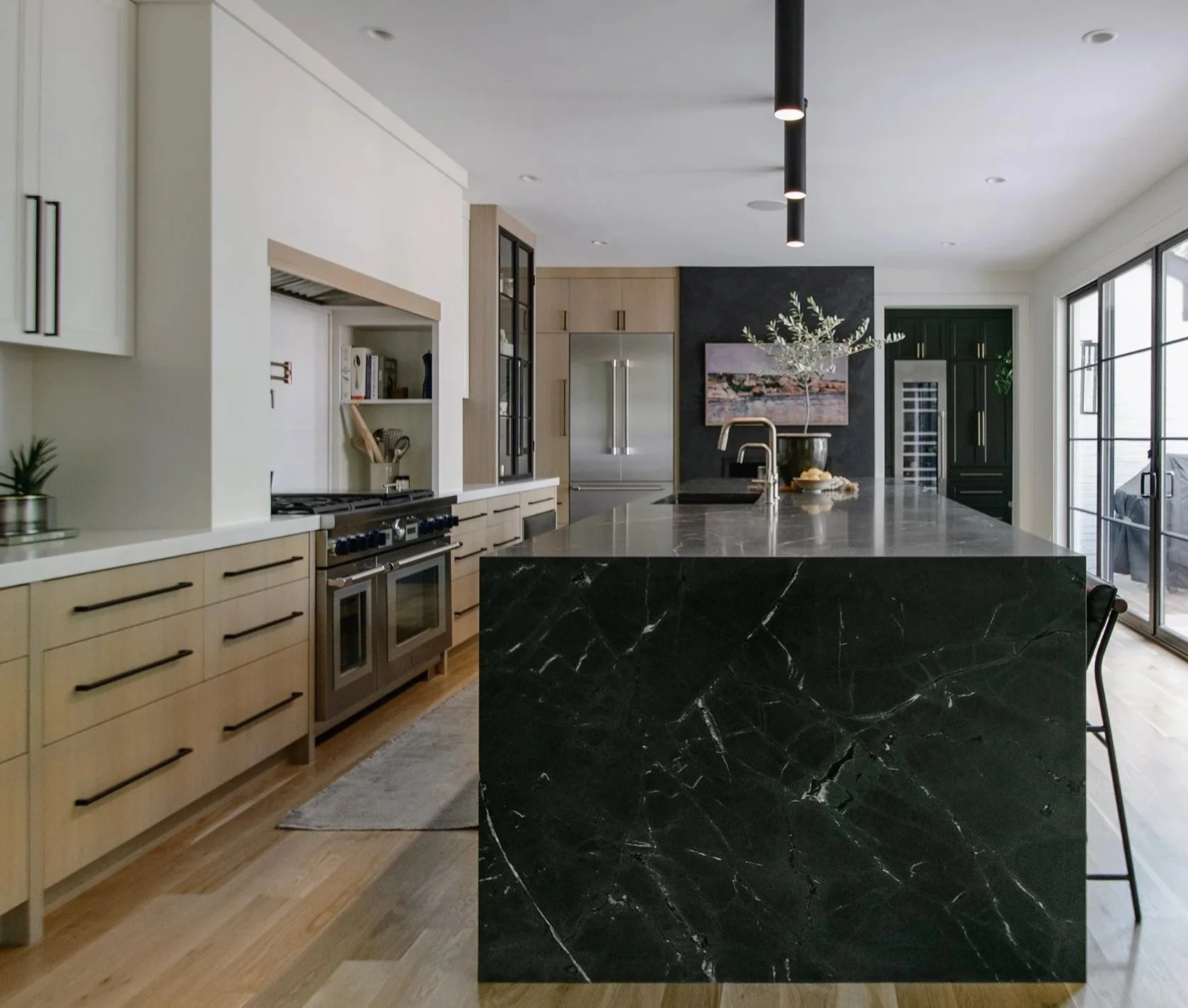 Award-winning kitchen remodel on Ward Parkway in Kansas City featuring custom white oak cabinetry, a waterfall stone island, integrated appliances, and refined modern detailing by Erica Kay Design & Remodeling.