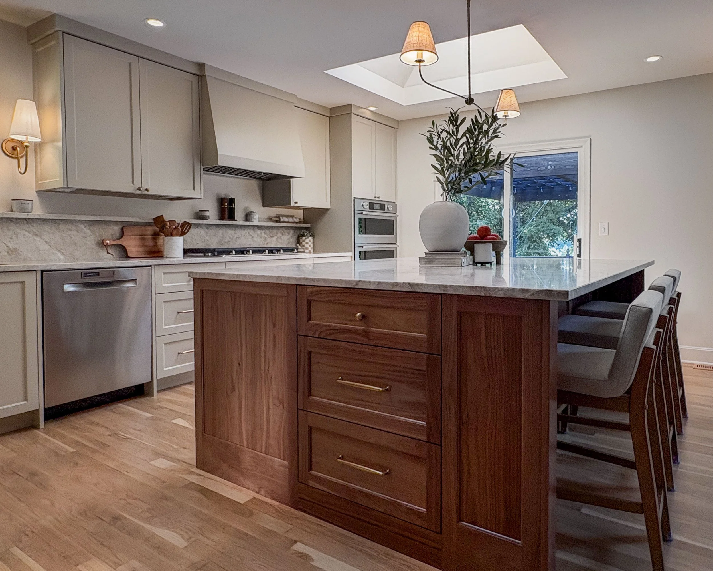 Remodeled Prairie Village kitchen with painted cabinetry, a walnut island, Taj Mahal countertops, and two large skylights.