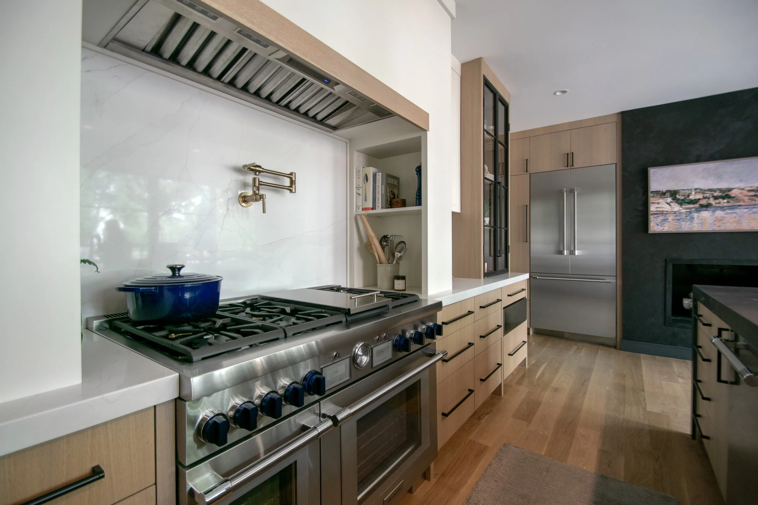 Luxury kitchen by Erica Kay Design & Remodeling, featuring rift sawn white oak cabinets, range alcove, pro-style range, and glass towers.