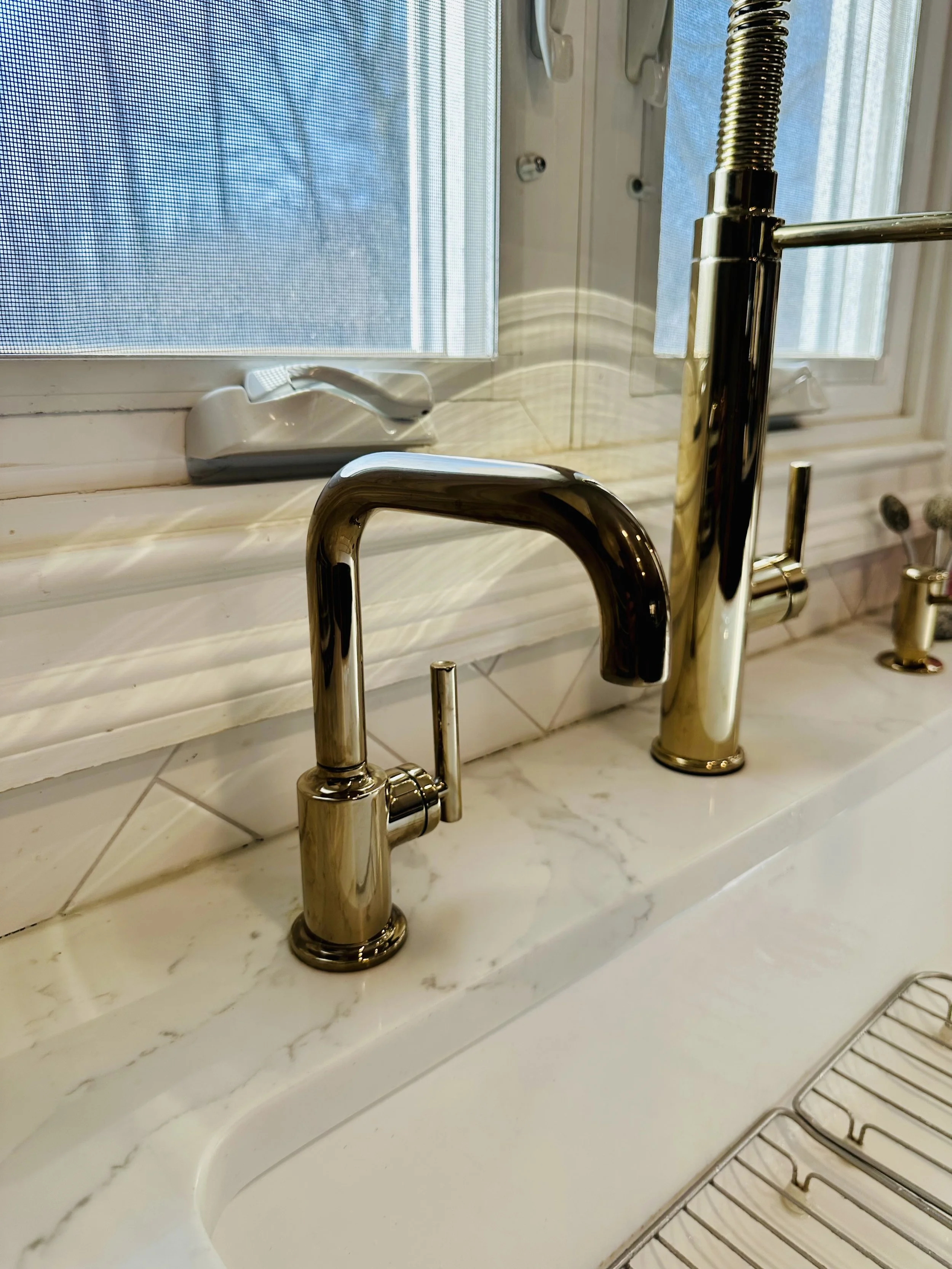 Champagne bronze reverse osmosis faucet installed by Alfano Water on a marble kitchen countertop