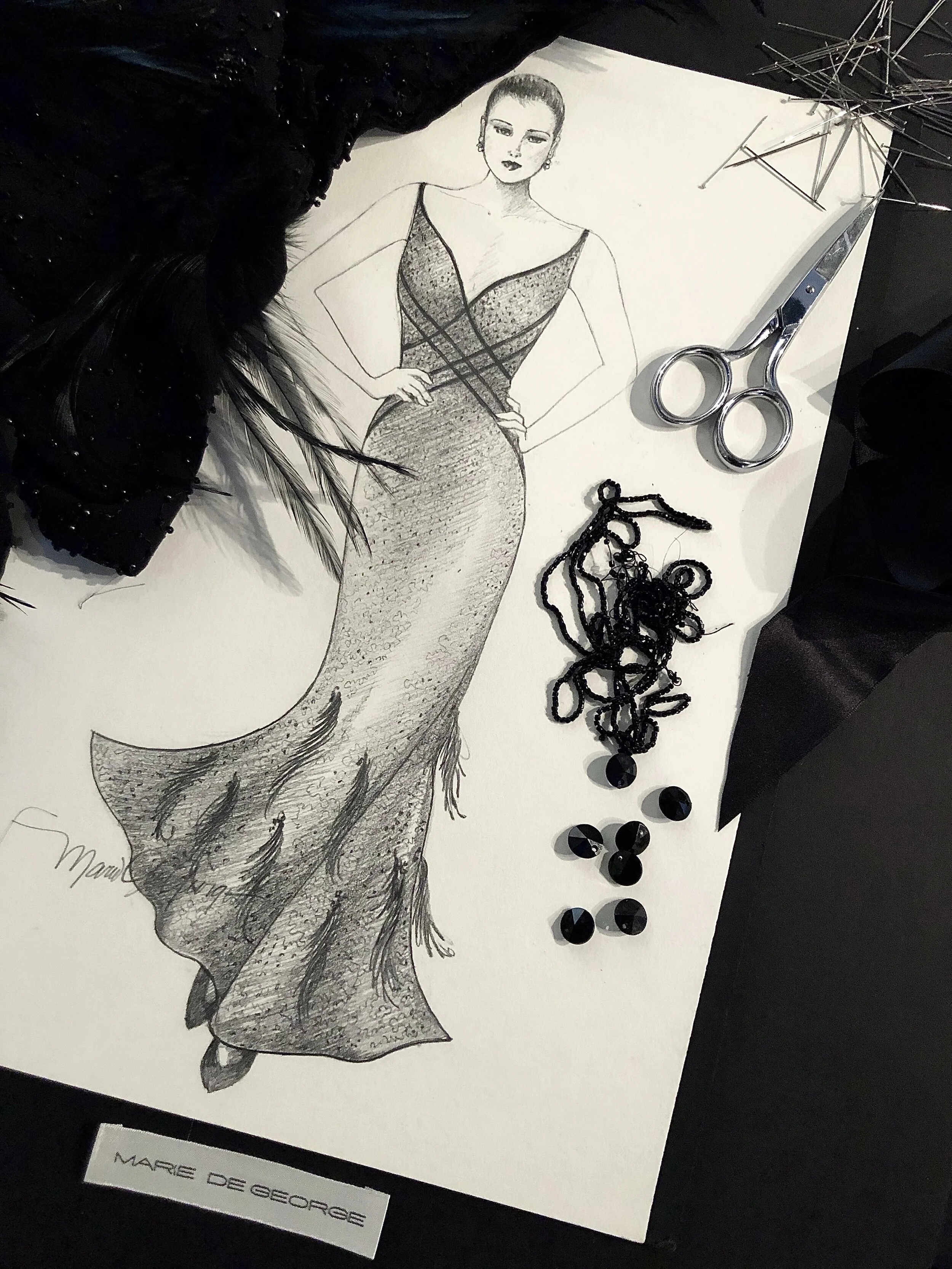 A fashion sketch of a woman in a form-fitting dress with a deep neckline, with accessories including a pair of scissors, black beaded necklace, and a decorative item resembling an umbrella. The sketch is signed by Marc de George.