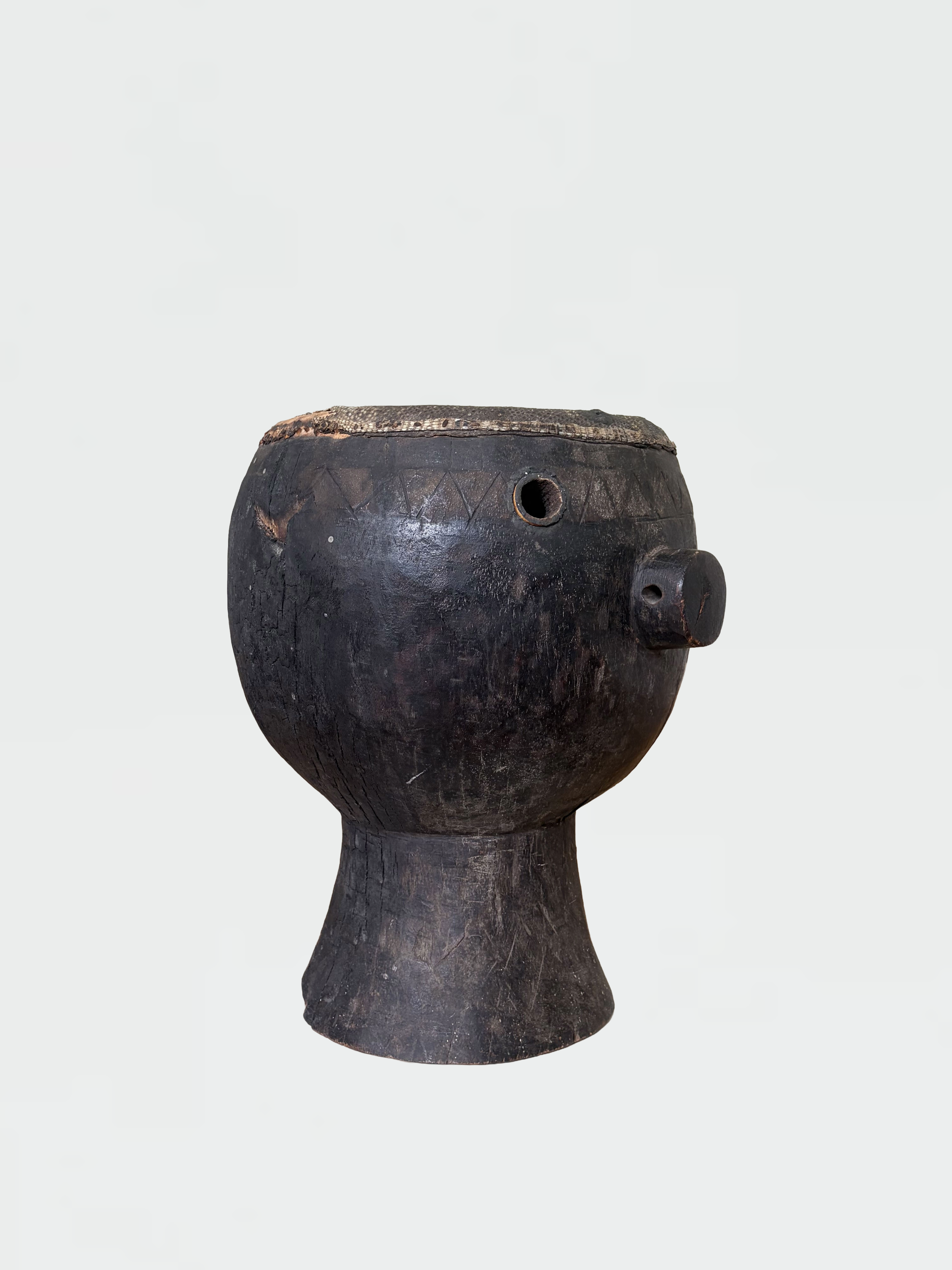 Ancient African wooden ritual mask with carved facial features and geometric patterns