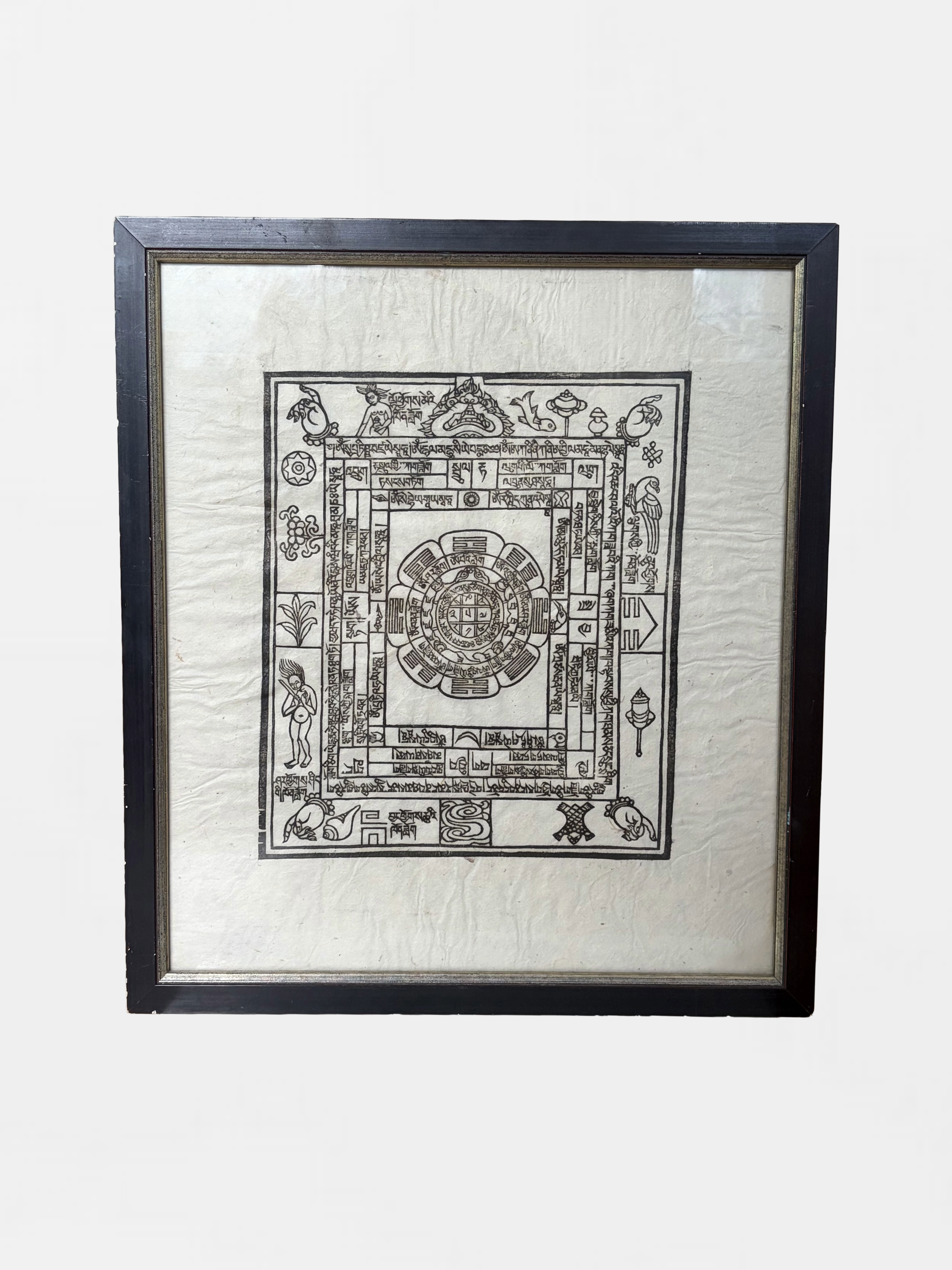 Framed black and white illustration resembling a traditional Tibetan or Buddhist diagram with intricate symbols and figures.