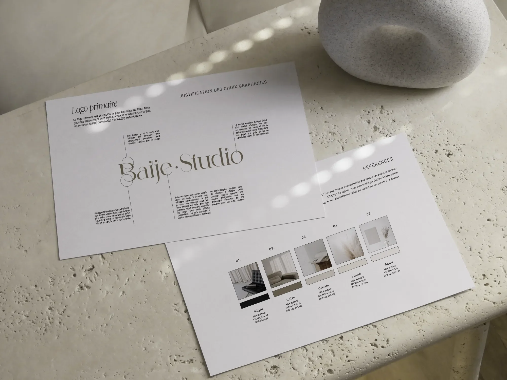 Une feuille d'échantillons de matériaux pour décoration intérieure, avec des couleurs et textures variées, accompagnée d'une brochure sur le design de logo et des choix graphiques, posée sur un comptoir en pierre clair.