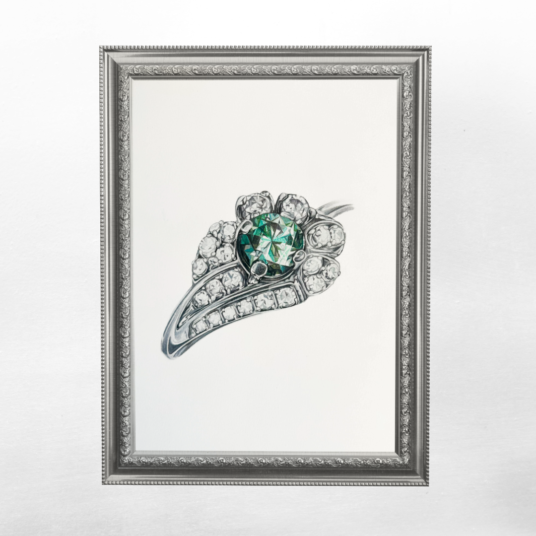 A framed custom artwork by Loventree showing a full color realistic drawing of a diamond ring with a large green gemstone and smaller clear diamonds surrounding it.