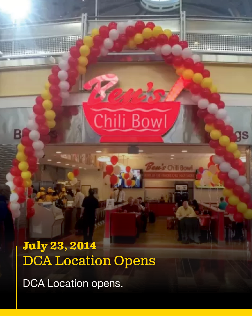 Grand opening of a Ben's Chili Bowl restaurant at DCA with red, yellow, and white balloon arch, and some people inside the restaurant.