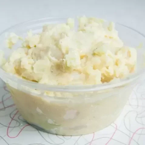 A clear glass bowl filled with mashed potatoes.