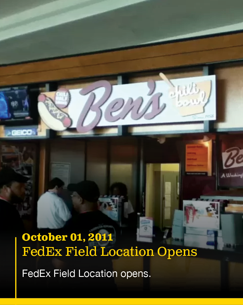 A fast food restaurant named Ben's with a hot dog logo. Inside, there are people waiting, and a menu board is visible.