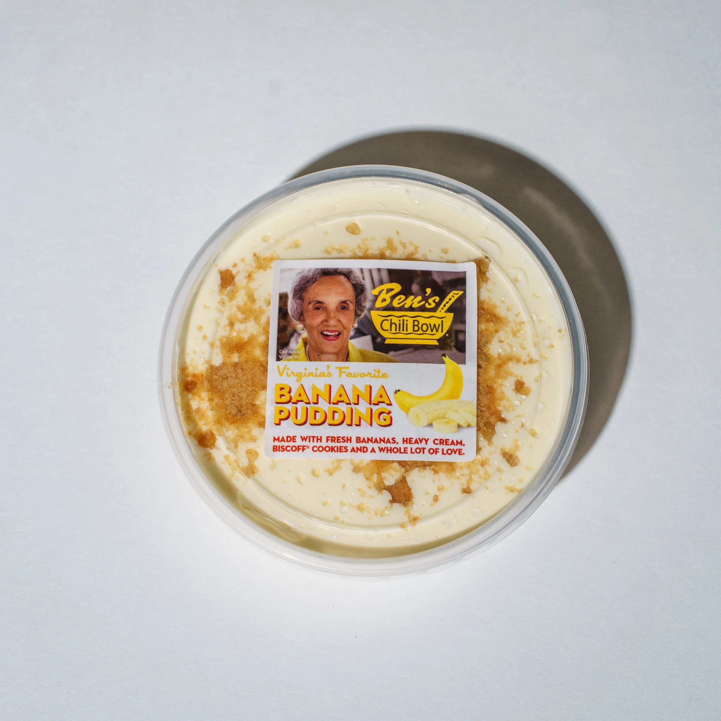 A jar of Ben's Chili Bowl sauce placed on a bunch of yellow bananas.