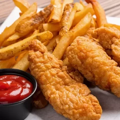 Fried chicken tenders with French fries and a cup of ketchup.