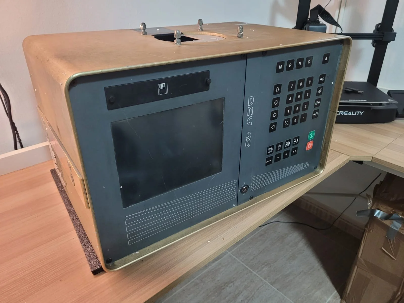 Aparato de computadora antiguo con pantalla y teclado en una mesa de madera.
