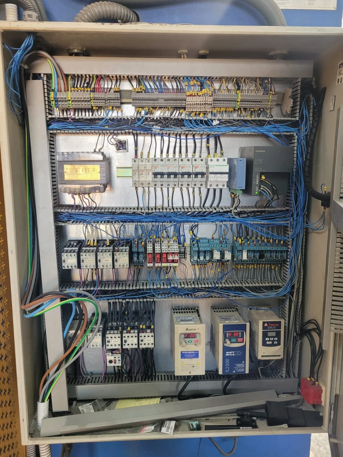 Panel eléctrico con componentes, cables y dispositivos electrónicos de control.