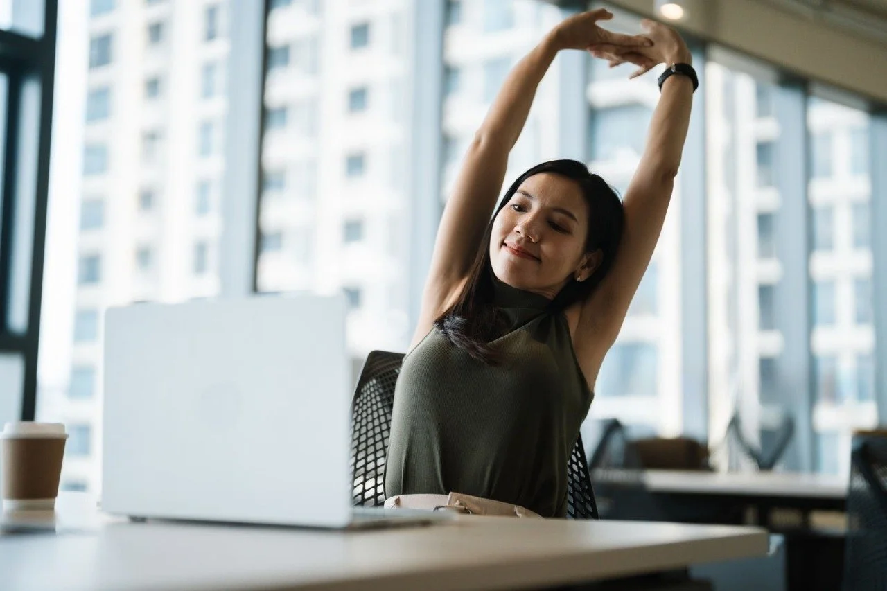 Office worker stretching shoulders at desk