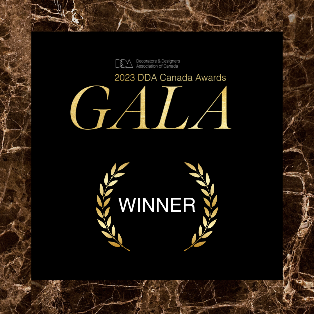An award plaque for the 2023 DDA Canada Awards, indicating a winner, with a black background, gold lettering, and a gold laurel wreath design, set on a brown marble border.