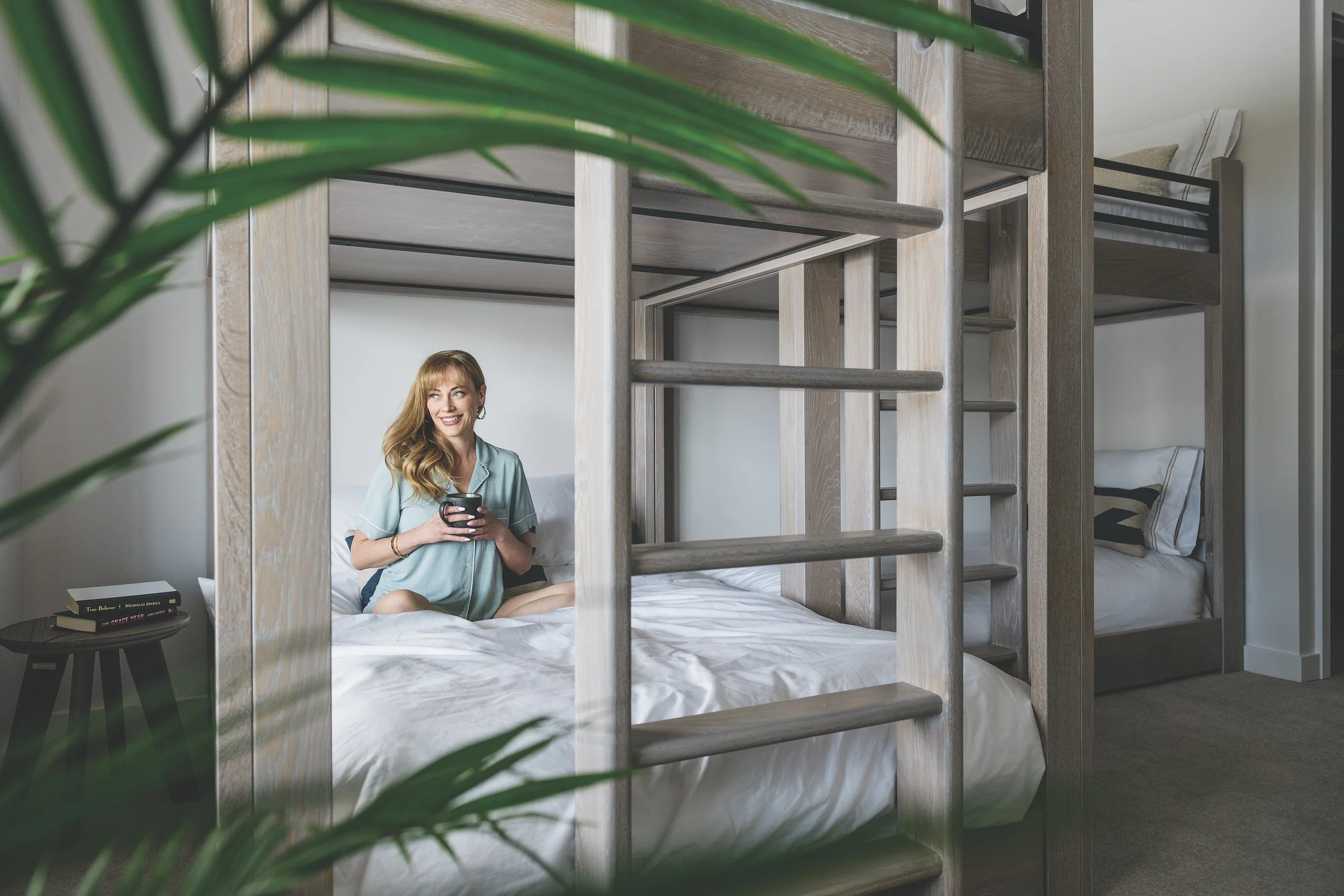 A women sitting on an ICON Bunk enjoying her morning coffee after a good nights sleep.