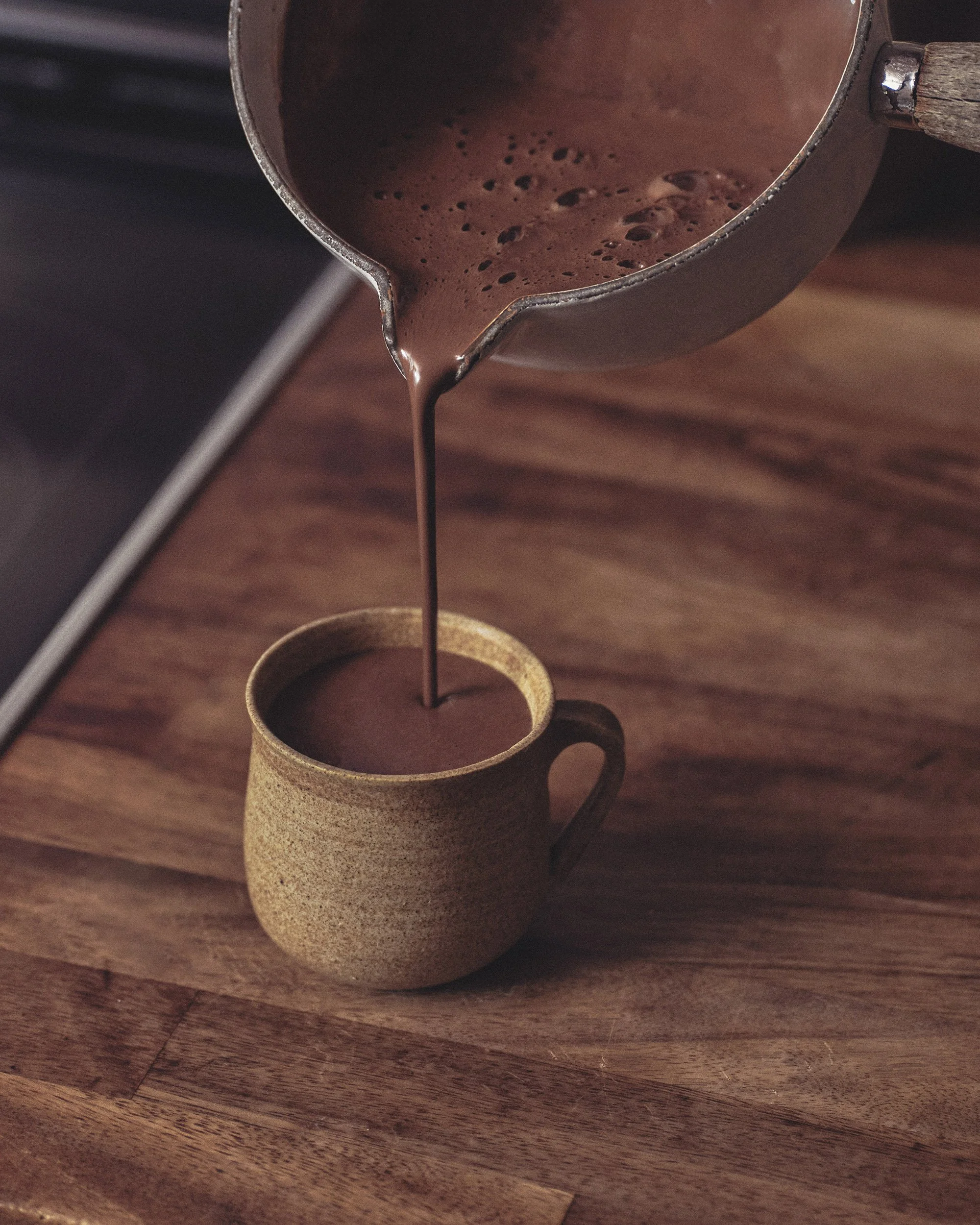 Preparing ritual cacao with whisk and ceramic cup