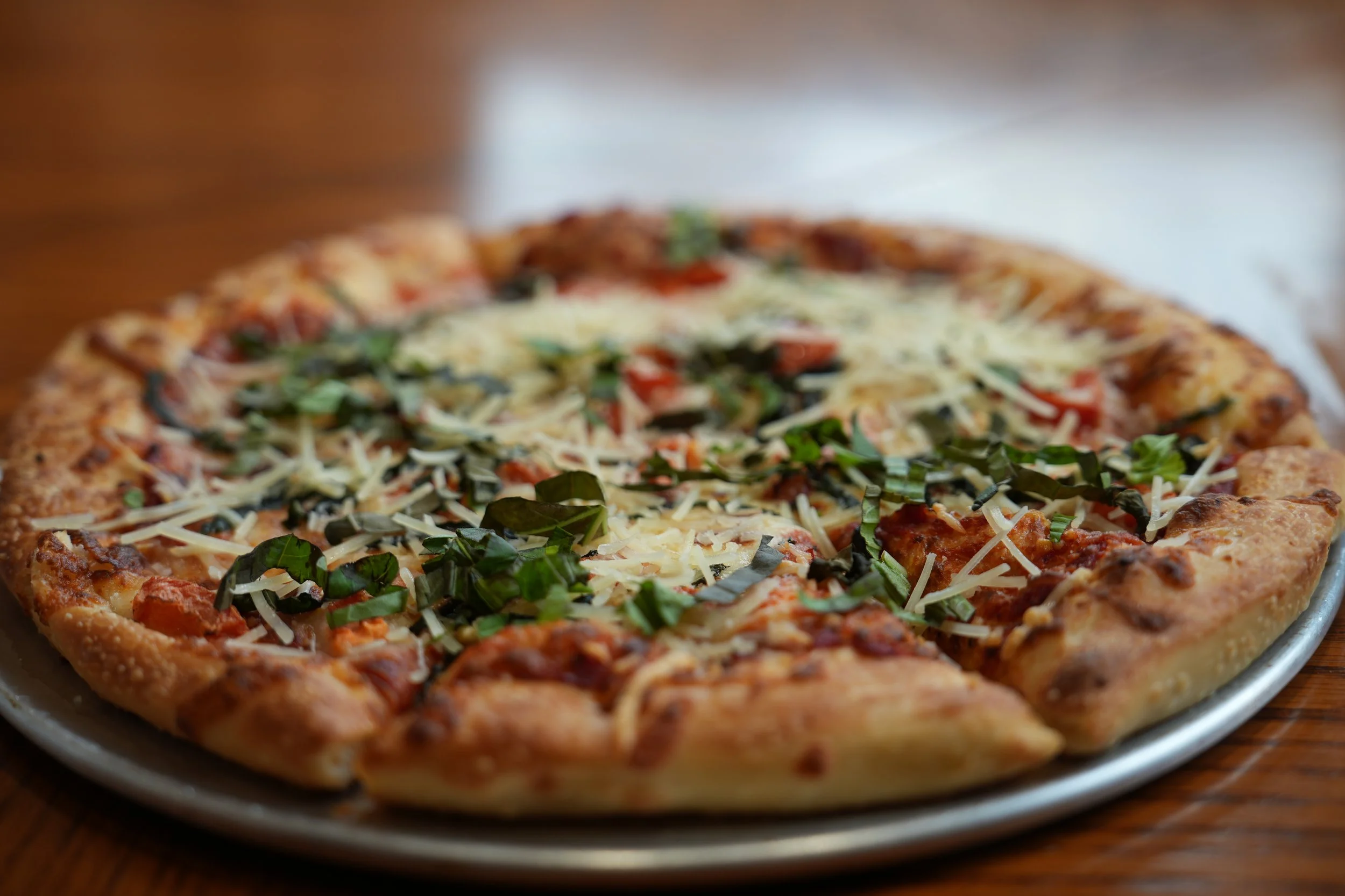 Hand-tossed margherita pizza with basil and parmesan, fresh from the oven at Castello Pizza & Pasta on Rainier Ave S, South Seattle