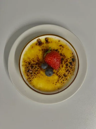 Crème brûlée décorée d'une fraise, deux myrtilles et du caramel croquant  - Aftersport Clavier