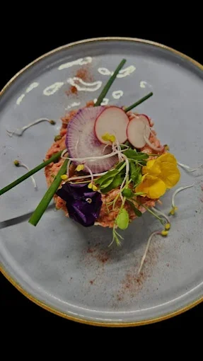 Assiette avec une salade de légumes et fleurs comestibles garnie de radis, radis noir, germes et herbes, présentation artistique  - Aftersport Clavier