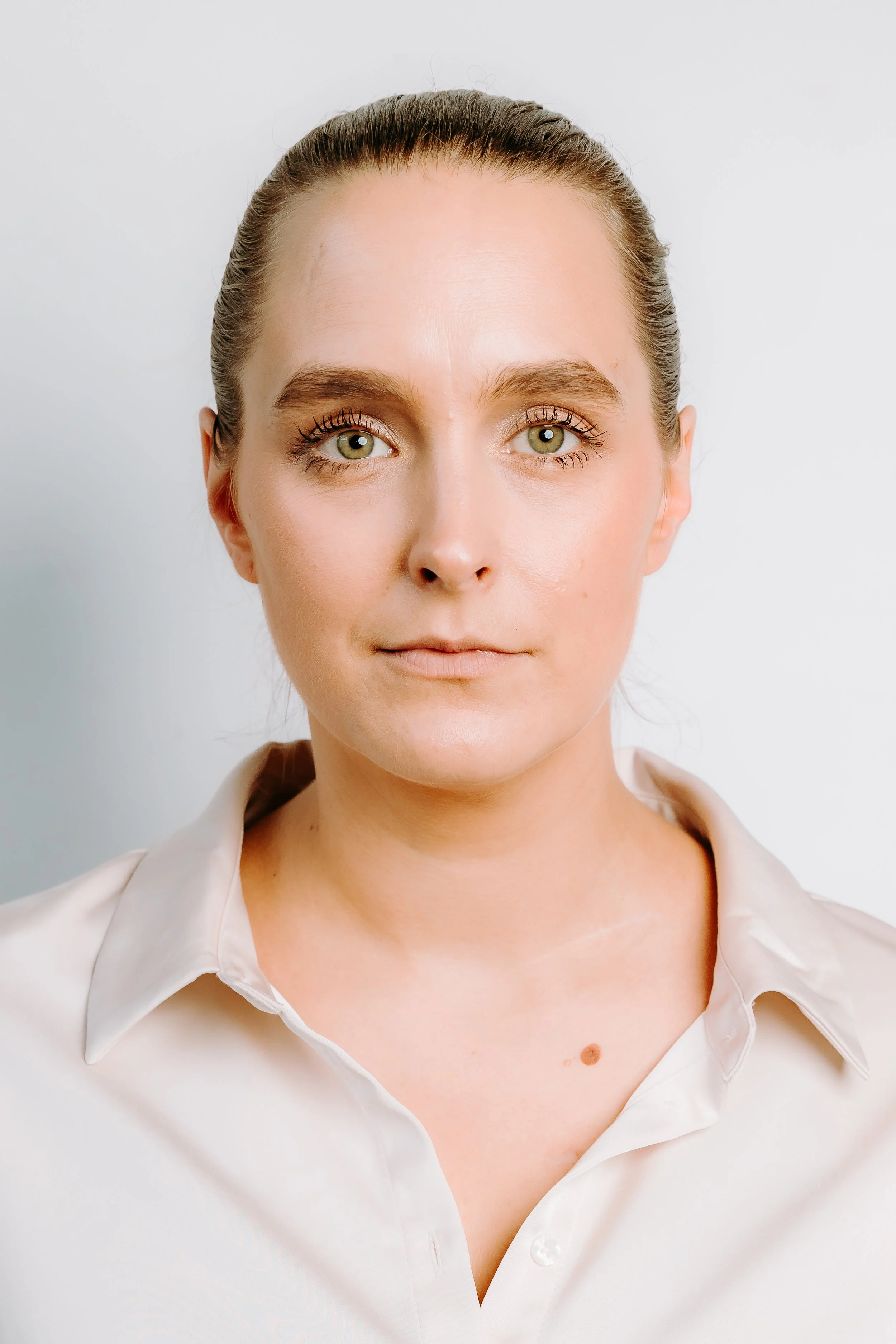 An images of Rebekah Carton, she is wearing a white shirt, she is looking slightly off camera.