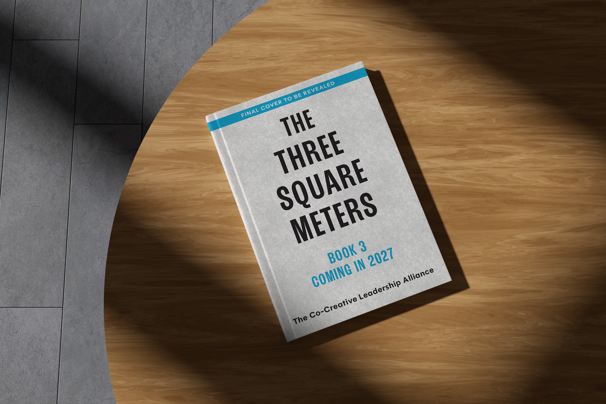 A book titled 'The Three Square Meters' lying on a wooden table. The cover indicates it is book 3, coming in 2027, published by the Co-Creative Leadership Alliance, with a final cover to be revealed.