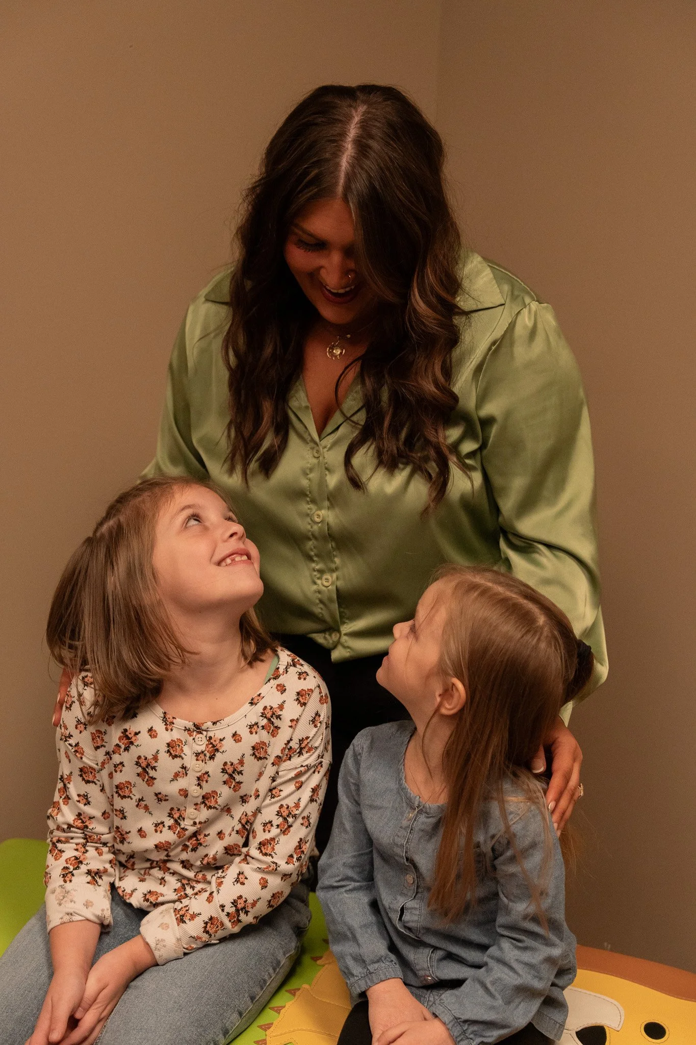 Dr. Sophia Duarte smiling with twoyoung children at Radiant Chiropractic in West Ashley, Charleston SC