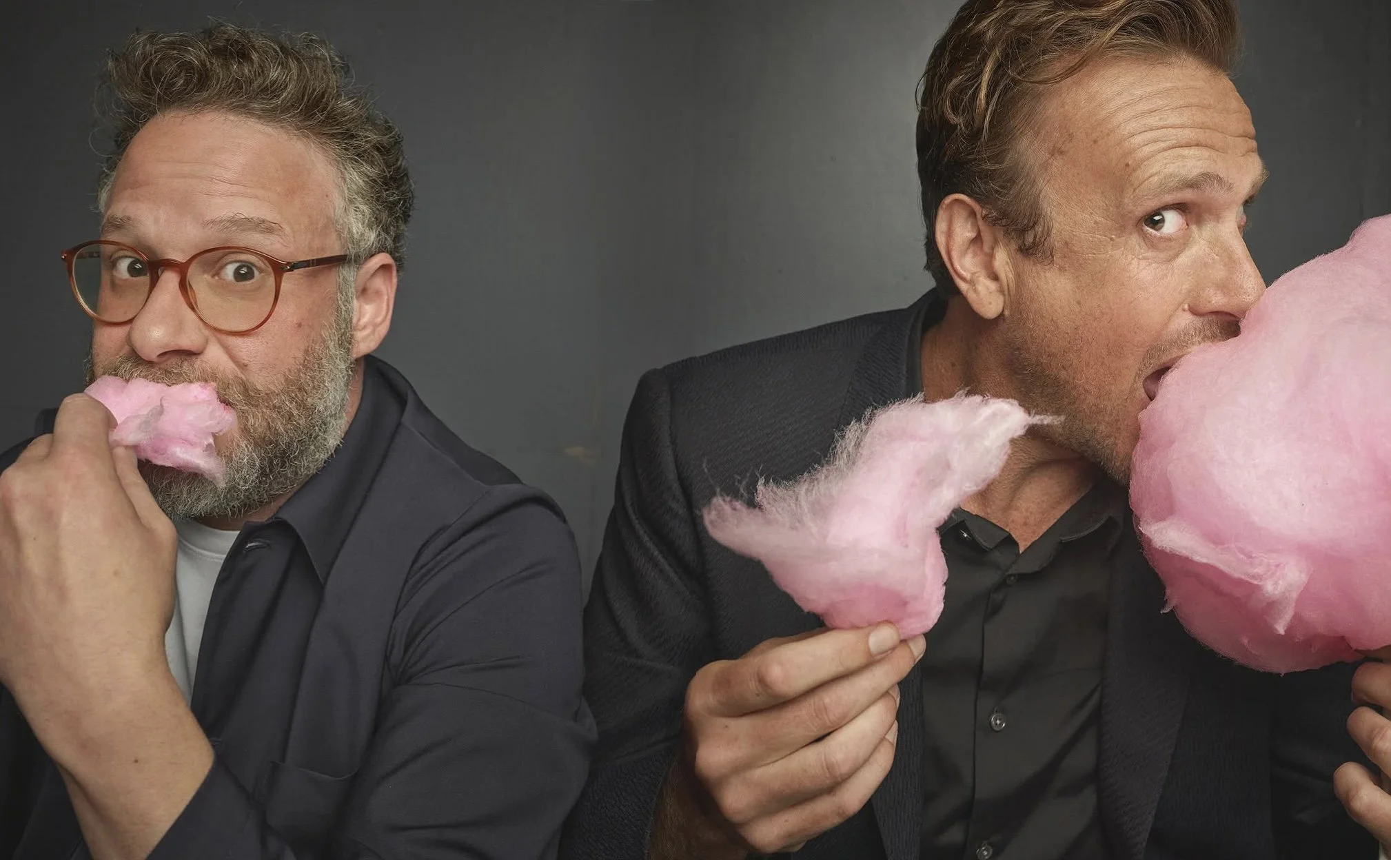 Seth Rogen and Jason Segal eating cotton candy on a grey background