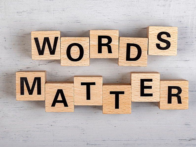 Wooden blocks spelling out "Words Matter" on a light wooden surface.