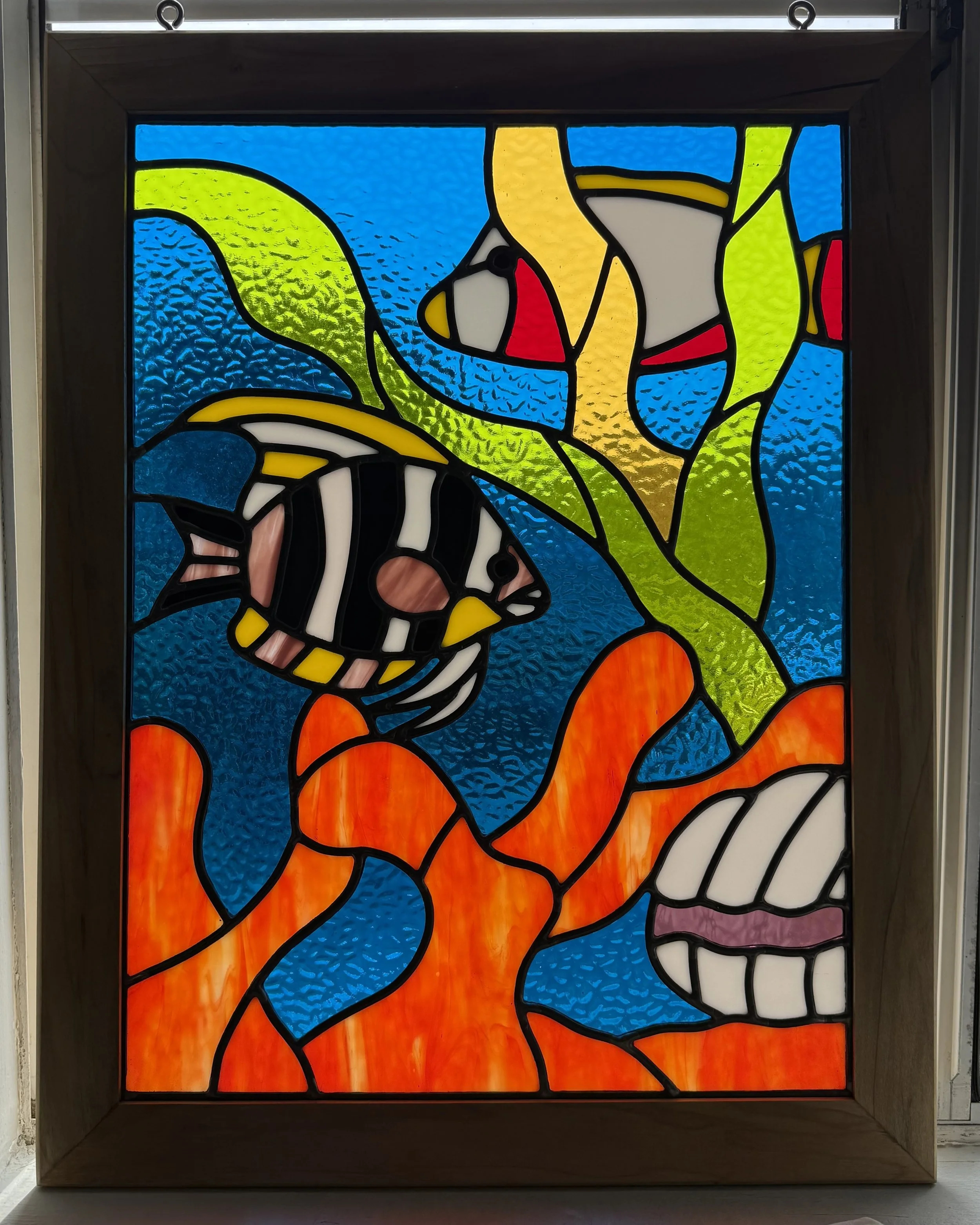 Colorful stained glass window depicting tropical fish and coral reef.