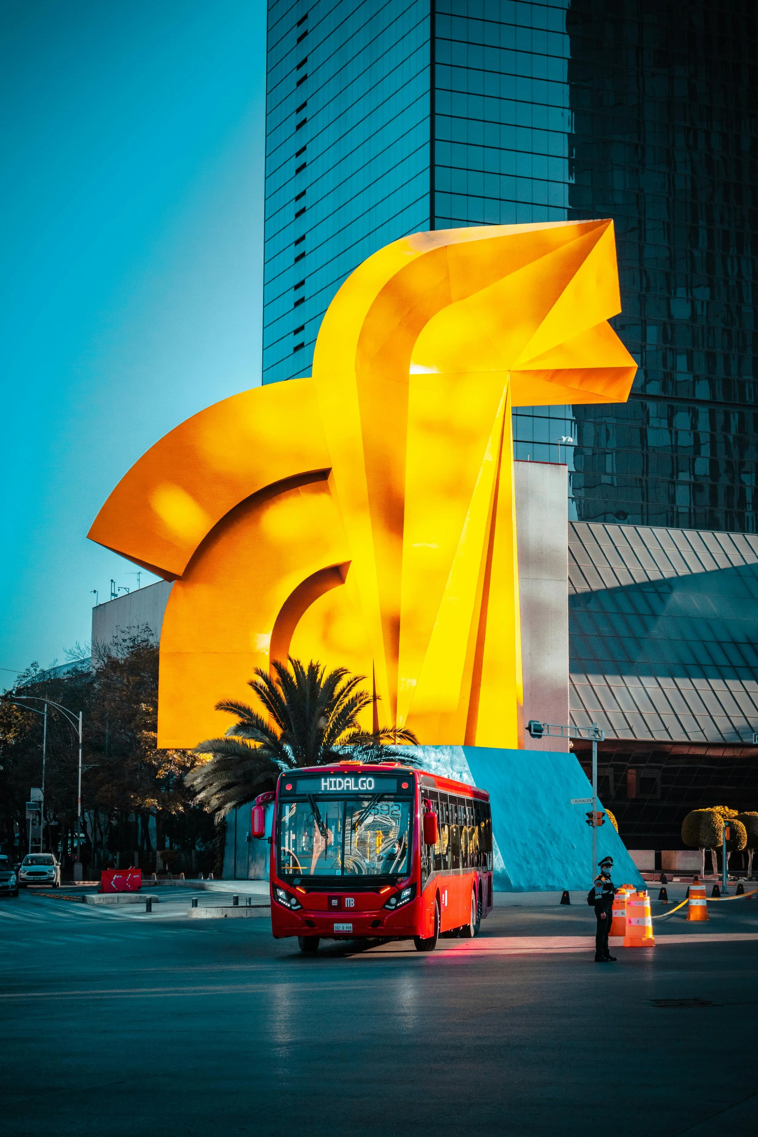 The yellow "caballito" sculpture on Mexico City's Reforma with a red bus in the foreground