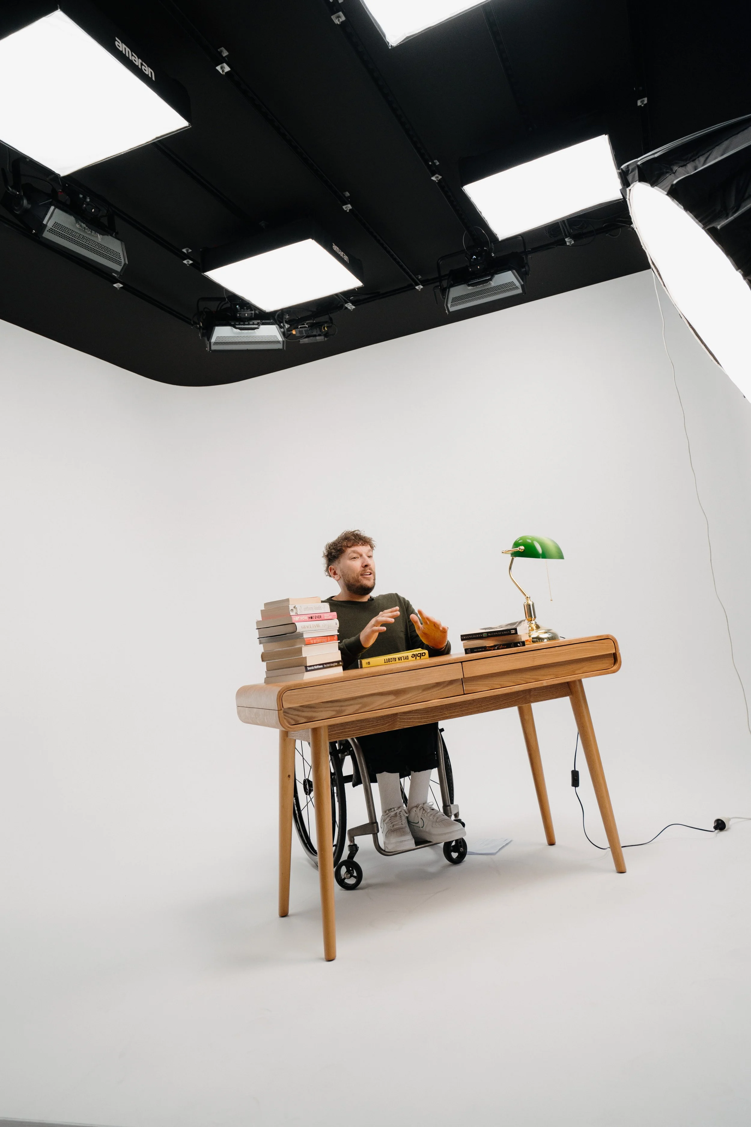Dylan Alcott being filmed sitting at a desk on Profile's cyclorama.