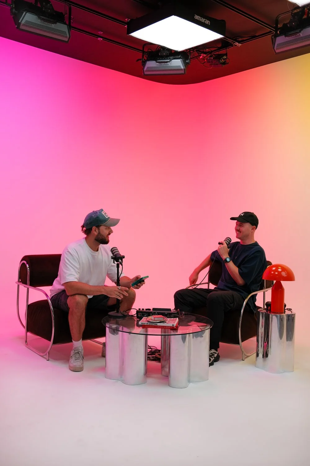 Two men using the cyclorama to record a podcast.