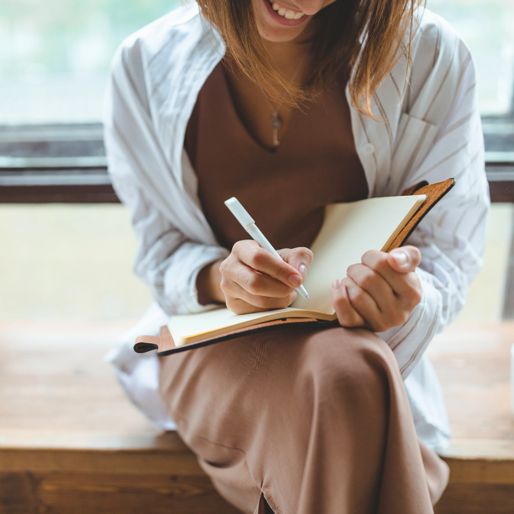 Creative professional writing ideas in a notebook during brand strategy planning