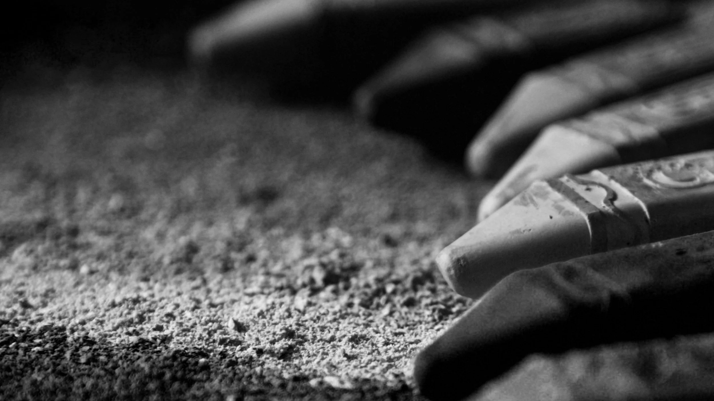 Range of crayons laying flat with a bunch of chalk dust underneath.